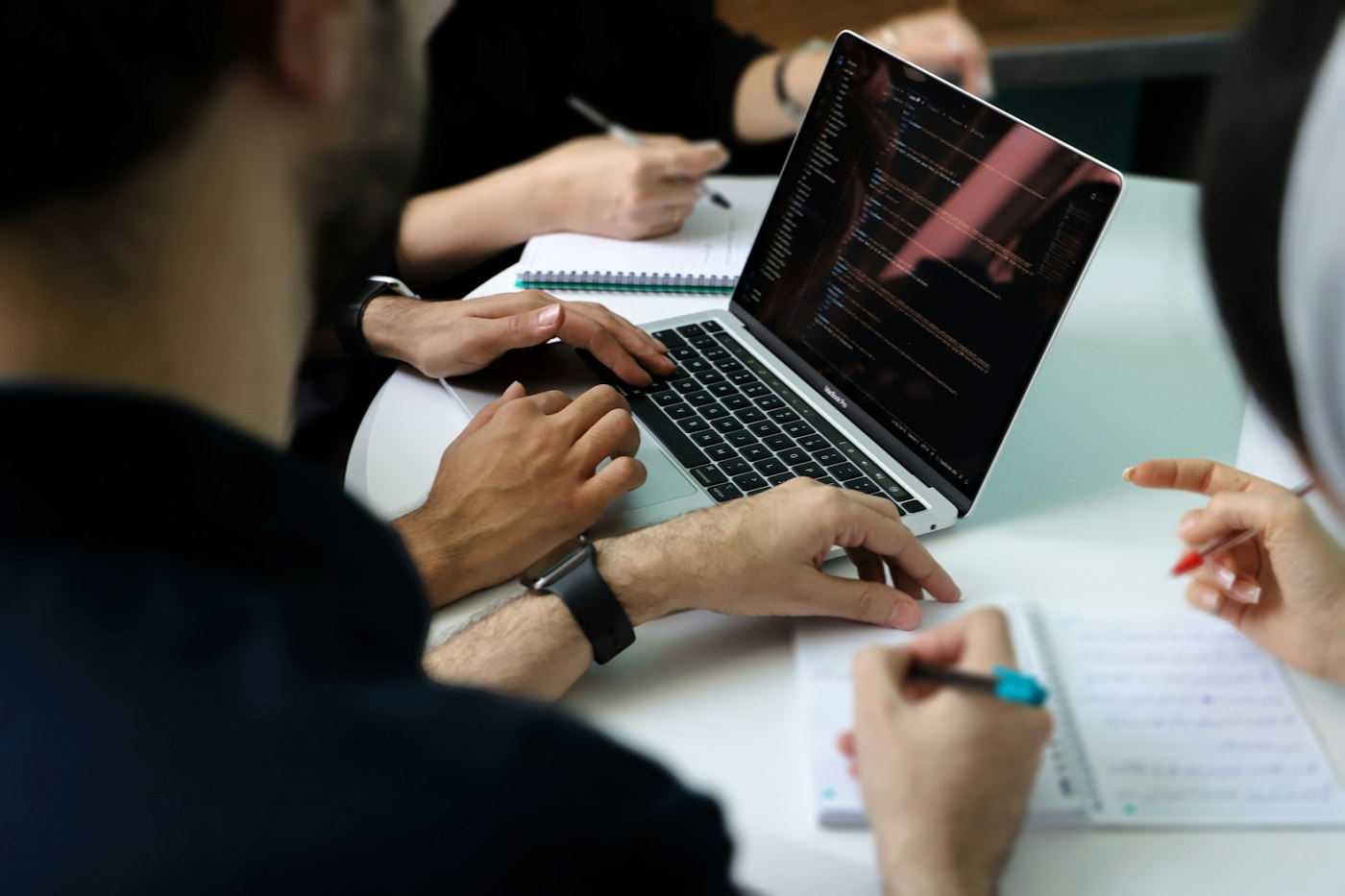 Equipo de desarrollo trabajando en código sobre una laptop