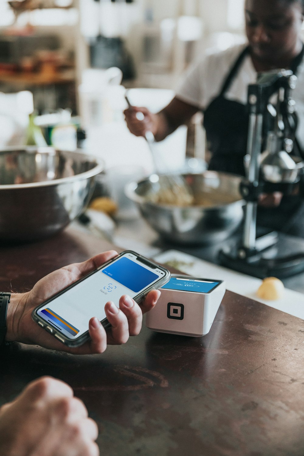 Cliente pagando con la tarjeta digital de su celular en un negocio real